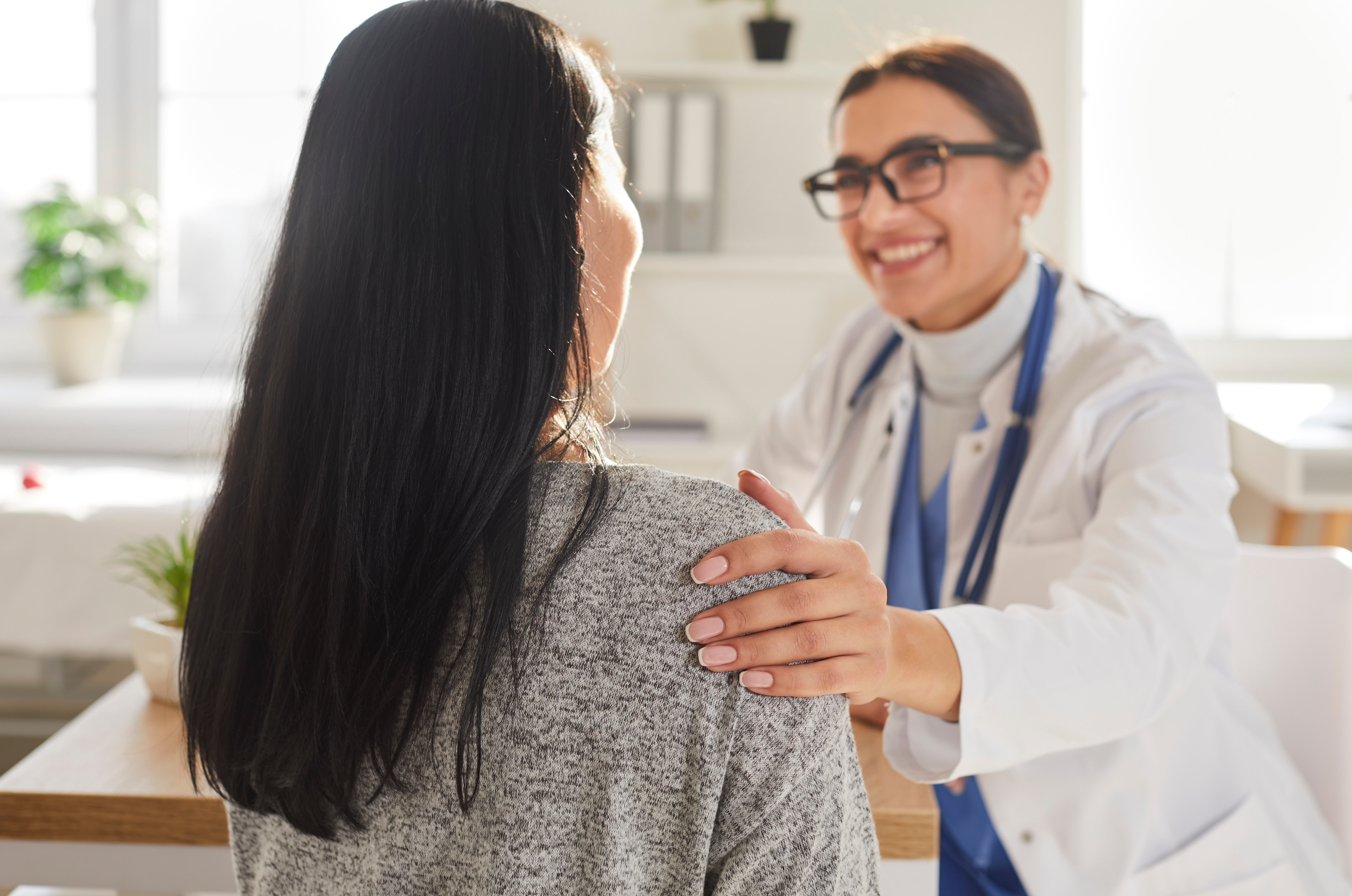 Smiling doctor putting their hand on a patients shoulder